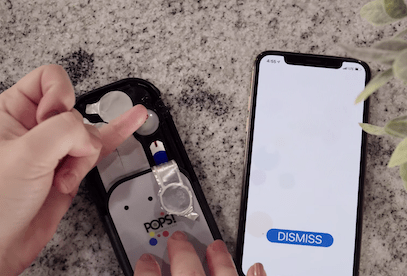 women testing blood with pinky finger using pops diabetes app
