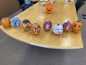 nine painted pumpkins on table