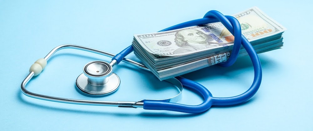 why is healthcare so expensive; money wrapped in stethoscope