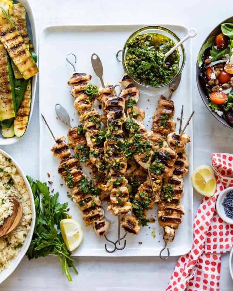 Chicken kebabs on a table of food