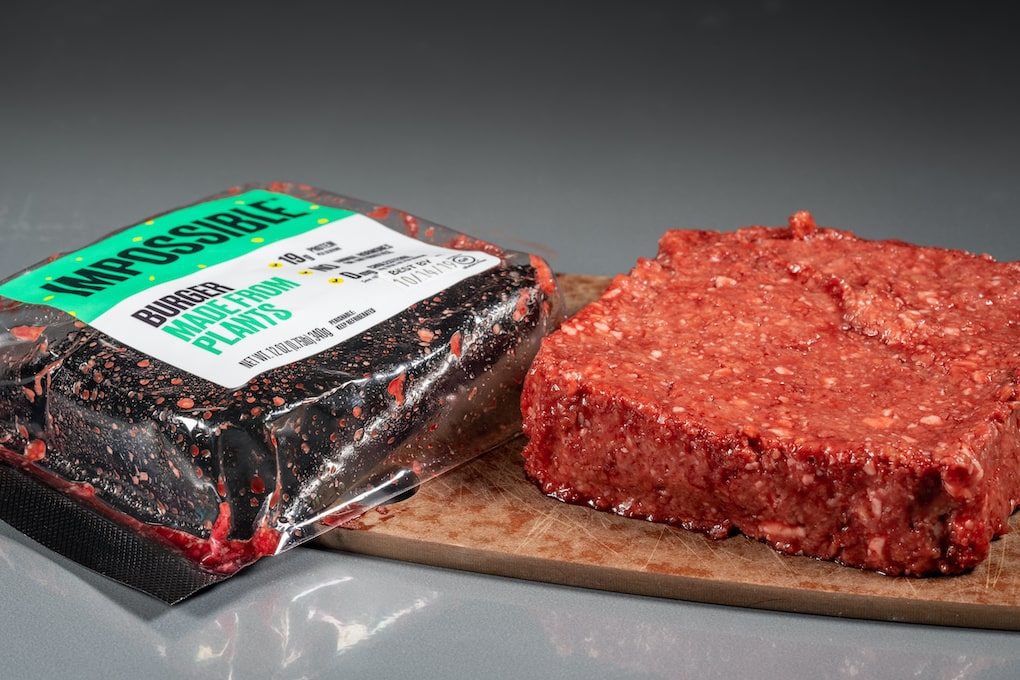 Packaging for Impossible Foods burger made from plants with raw product on steel background; is the impossible burger healthy
