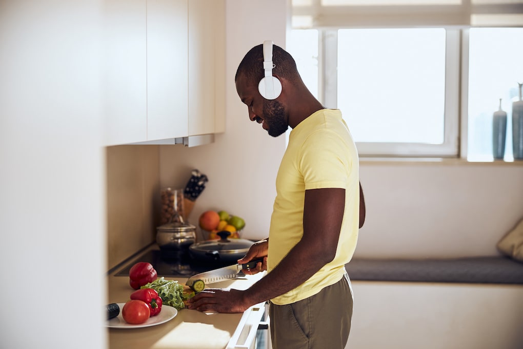 man cooking while listening to a diabetes podcast